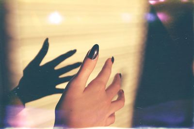 Close-up of woman hand against wall