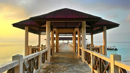 View of pier on beach against sky