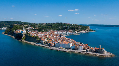 High angle view of townscape by sea against sky