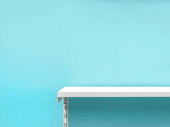 Close-up of white table against blue wall at home