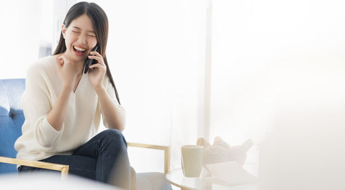 Smiling young woman using mobile phone