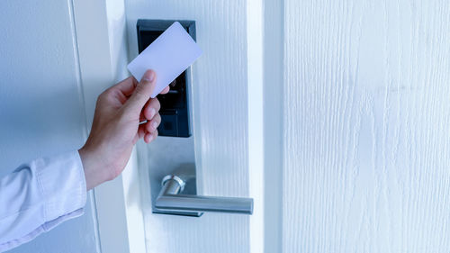 Midsection of man holding white door