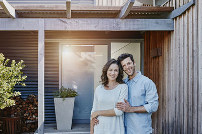 Couple standing in front of door of their home