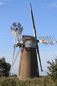 Low angle view of traditional windmill against sky