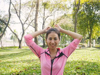 Portrait of smiling young woman standing on field