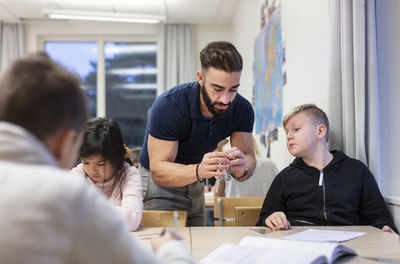 Teacher with schoolboy in classroom