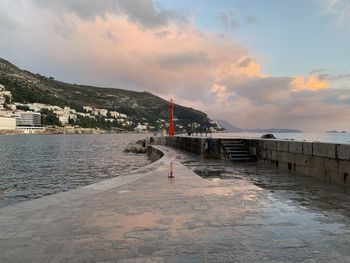 Pier over sea against sky during sunset