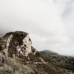 Scenic view of mountains against cloudy sky