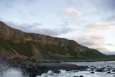 Scenic view of sea and mountains against sky