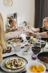 Group of friends raising toast during mexican feast