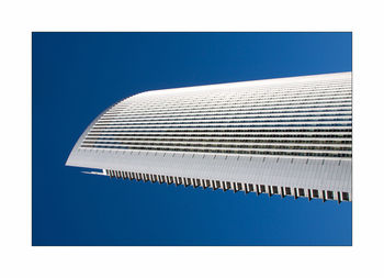 Low angle view of modern building against blue sky