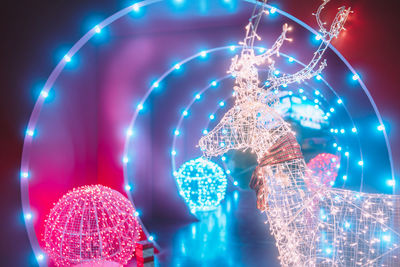 Low angle view of illuminated lighting equipment at night