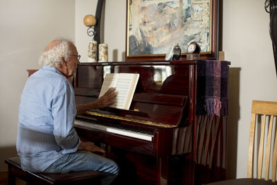 Senior man playing piano at retirement home