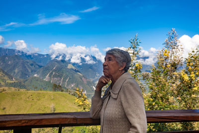 Senior woman tourist looking at the  landscapes of the central ranges in colombia. travel concept