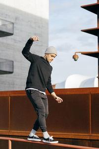 Athletic man doing parkour balance exercises outdoors in urban scene person