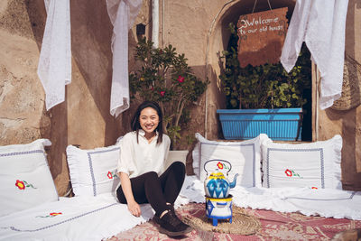 Portrait of smiling young woman sitting outdoors