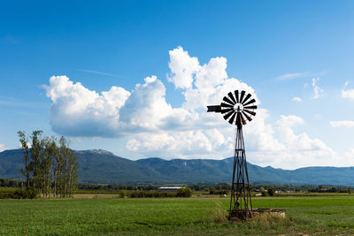 Windmill on field against sky