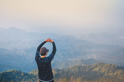 Wanderlust and relax in nature from hiker man camping with success and happiness on top of mountain