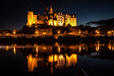 Reflection of building in lake at night