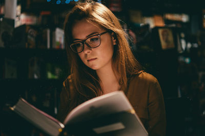 Close-up of young woman using smart phone at night