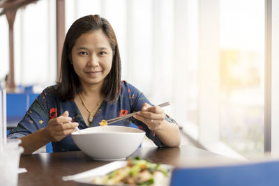 Portrait of woman holding ice cream in bowl