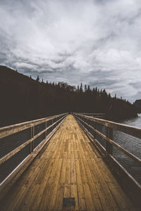 View of footbridge over sea against sky