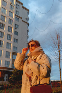 Side view of woman standing against trees