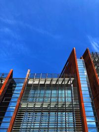 Low angle view of modern building against blue sky