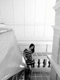 Beautiful woman leaning on balustrade against wall