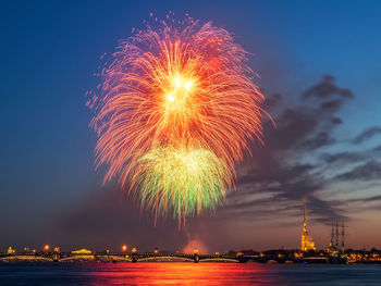 Firework display over river at night