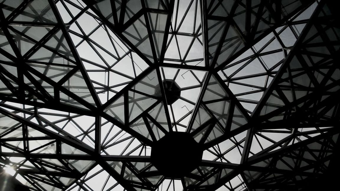 low angle view, built structure, architecture, ceiling, directly below, sky, indoors, pattern, geometric shape, backgrounds, full frame, architectural feature, skylight, no people, day, design, glass - material, metal, silhouette, modern