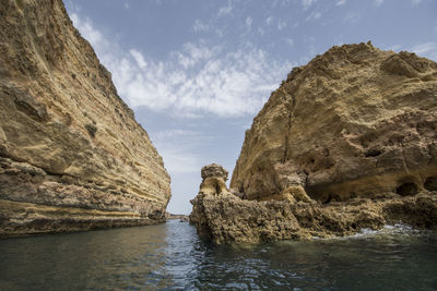 Rock formations by sea against sky