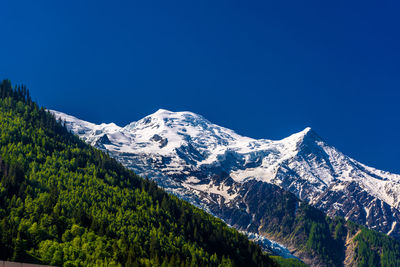 Scenic view of snowcapped mountains against blue sky