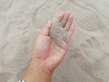 High angle view of hand holding sand