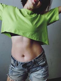 Midsection of woman standing against wall