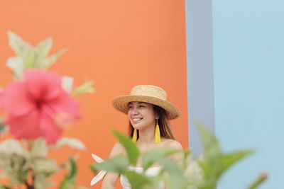 Young woman wearing hat with flowers