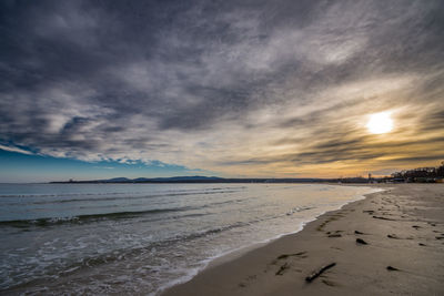 Scenic view of beach against sky during sunset