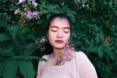 Portrait of woman with pink flower