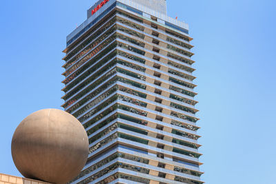 Low angle view of modern building against clear blue sky