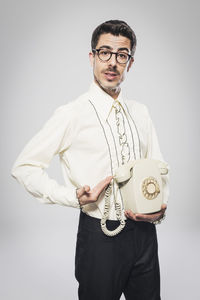 Portrait of young man standing against white background