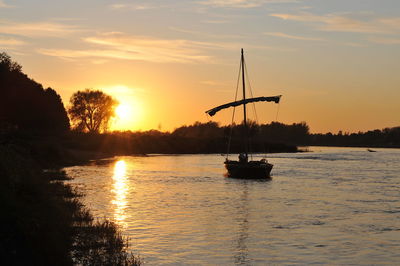 Silhouette boats in sea against sky during sunset