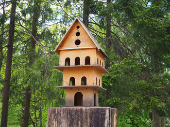Low angle view of birdhouse against trees in forest