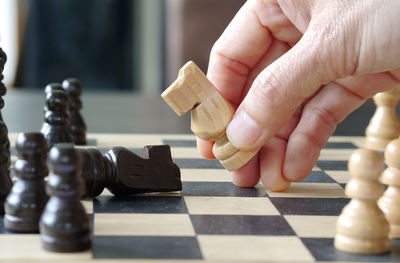 Cropped hand of person playing chess 