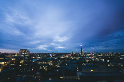 Illuminated cityscape against sky at night