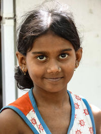 Close-up portrait of girl against wall