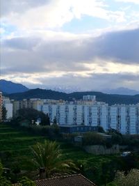 Scenic view of sea by cityscape against sky