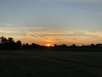 Scenic view of silhouette field against sky during sunset