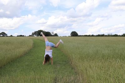 Rear view of man on field against sky