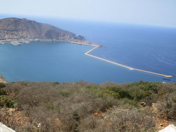 Scenic view of sea and mountains against sky