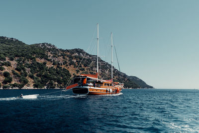 Sailboat sailing on sea against clear sky